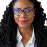 Professional Black woman with glasses and locs smiling confidently.